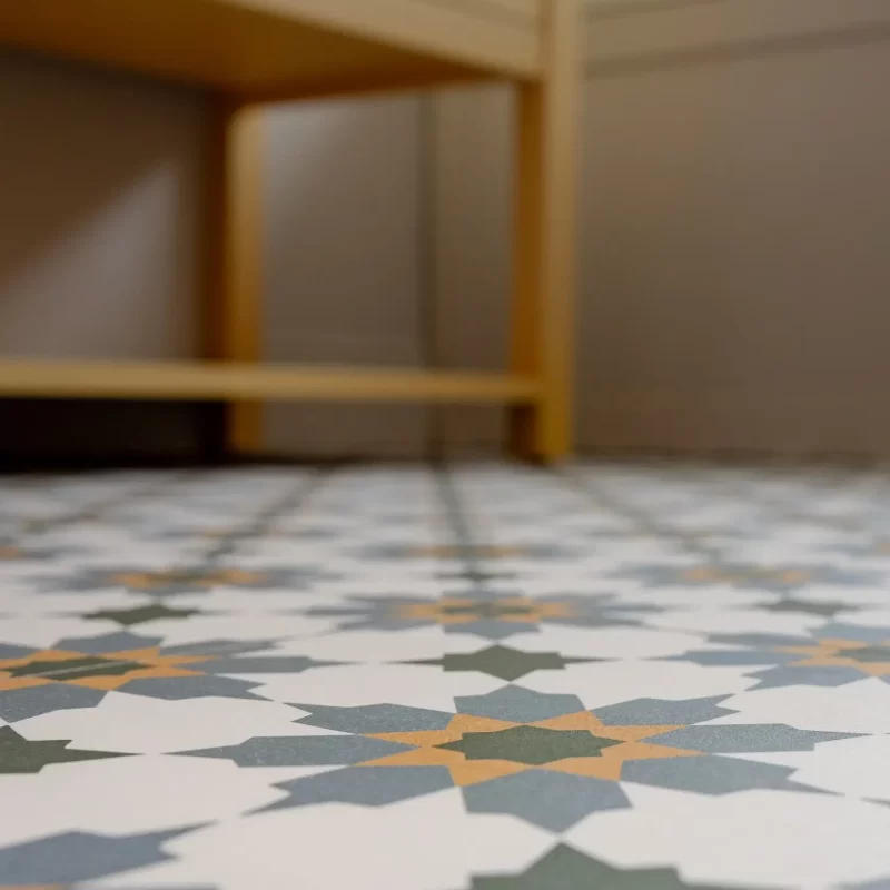 Geometric patterned bathroom floor tiles in blue, green, and mustard